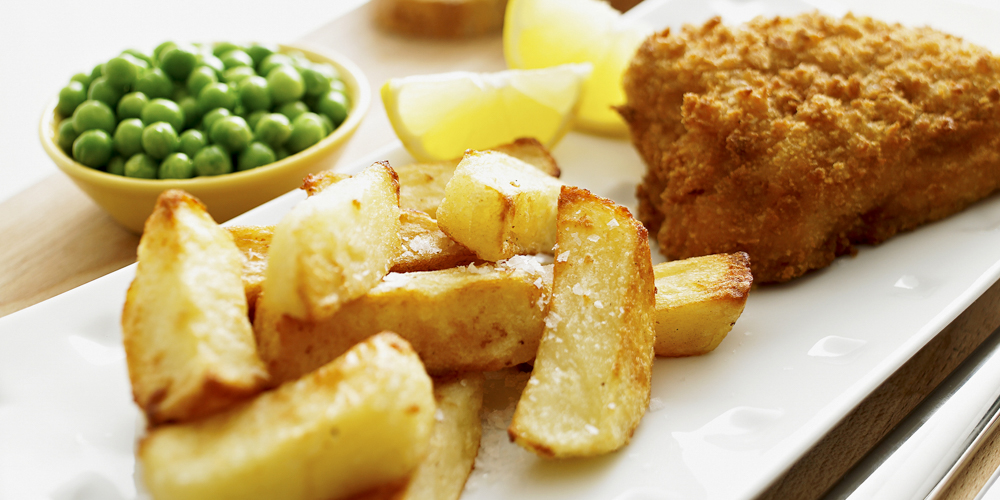 Tasty fish and chips with lemon, side peas.