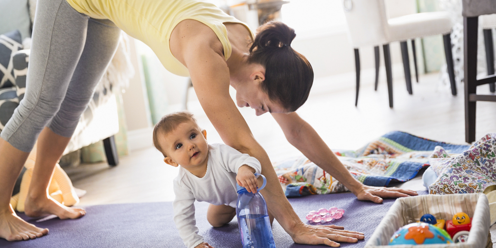 Mother practicing yoga by baby at home
