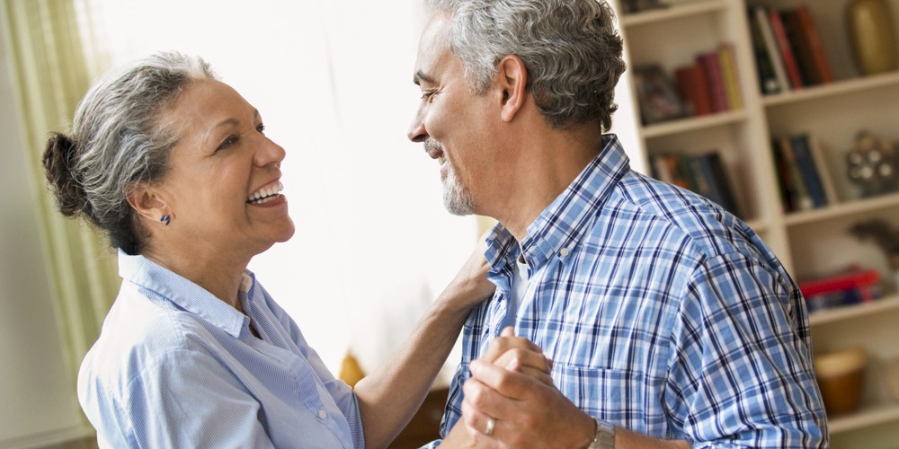 Hispanic couple dancing in living room